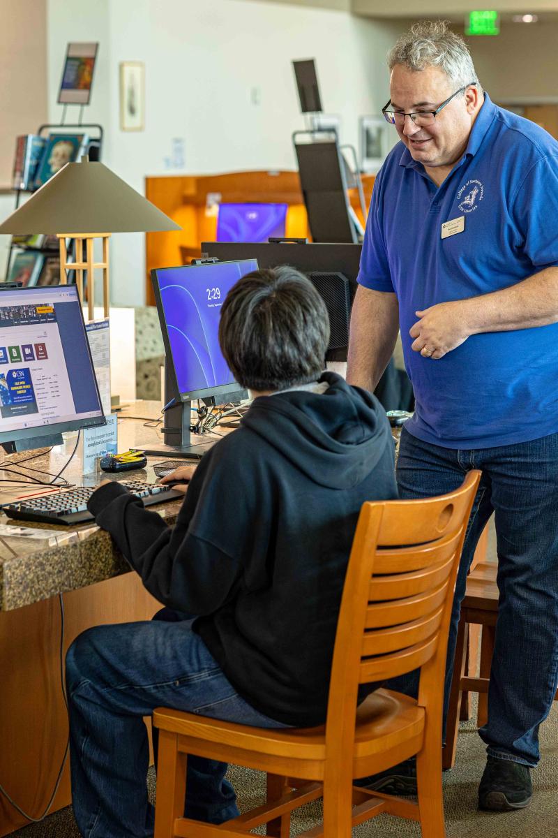 CSN Librarian helping a student at a computer
