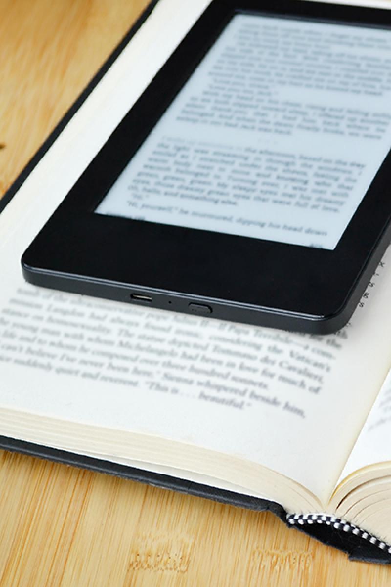 A photo of a eReader tablet on a book