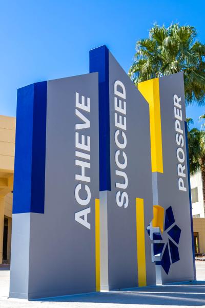 A photo of pillars with the words "Achieve", "Succeed", and "Prosper" at the CSN West Charleston Campus